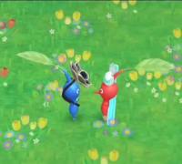 Two Pikmin greet each other with an enthusiastic wave.