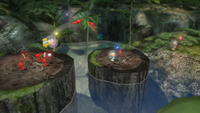 Early E3 2012 screenshot of Alph throwing Brittany and her Red Pikmin to a tree stump.