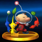 A trophy for Captain Olimar in the 3DS version of Super Smash Bros. for Nintendo 3DS and Wii U, throwing a Red Pikmin while guarded by a Yellow Pikmin and a Blue Pikmin.