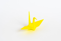 Real life image of a yellow origami crane.