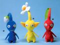 Promotional image of a leaf Red Pikmin, a flower Yellow Pikmin, and a bud Blue Pikmin.