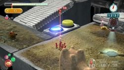 Captain Olimar aims a Red Pikmin at a conveyor belt in Clockwork Chasm.